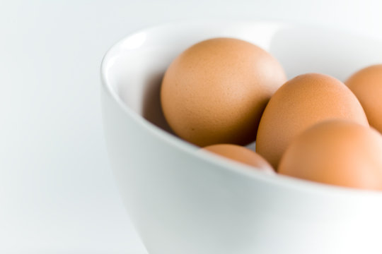 Fresh Brown Eggs in Tilted White Bowl