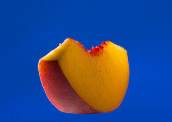 thin slice of peach isolated on blue
