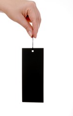 Female hand and black paper tag isolated on white..