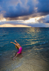 Fototapeta na wymiar woman doing yoga and stretches on the beach at sunrise.