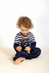 Fototapeta premium A little girl studies a telephone.