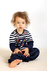 A little girl studies a telephone.