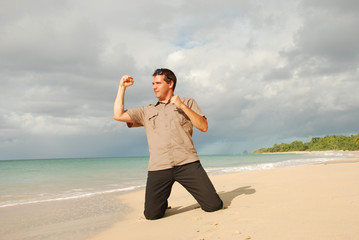 Homme sur une plage levant le poing