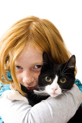 red head girl holding a black white kitten