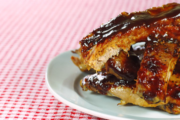 Barbecue cut up spare ribs on a checkered tablecloth