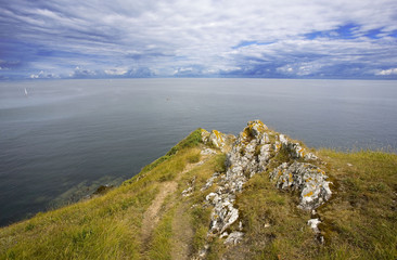 bretagne,belle-île,côte nord : chemin, rochers et nuages en bord