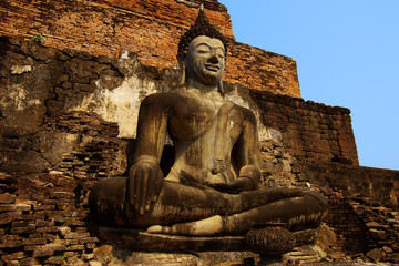 Statue of a sitting deity in historical park Sukhothai.