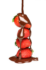 Pouring melted chocolate over four strawberries - 10687801