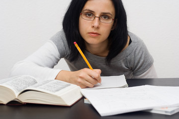 young caucasian woman sitting behind the desk and studying