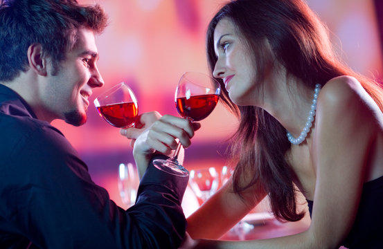 Young Couple Celebrating With Red Wine At Restaurant