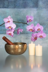 Klangschale mit Orchideenblüten und Kerzen