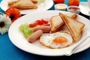 Breakfast - toasts, egg, sausage and vegetables
