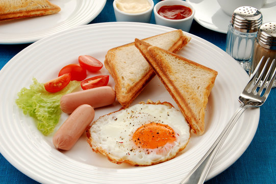 Breakfast - toasts, egg, sausage and vegetables