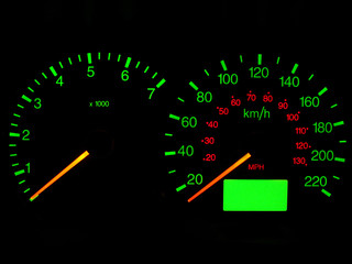 Close up of a car dashboard gauges at night