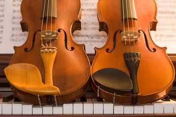 Two violins on top of piano keys