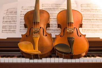 Two violins on top of piano keys