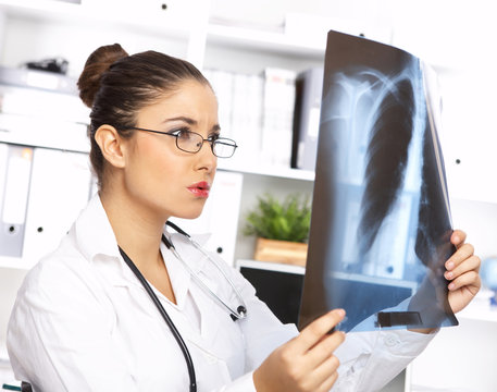 Portrait of female doctor examining x-ray picture