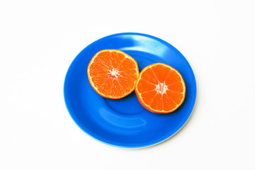 Zwei halbe Clementinen auf einer blauen Untertasse