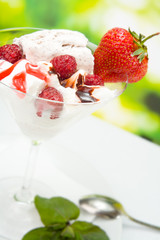 Ice-cream with strawberry and raspberry, outdoors