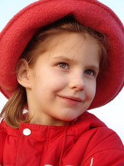 little smiling girl evening portrait in red