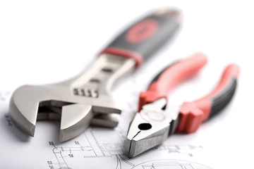 wrench and pliers over technical drawing isolated