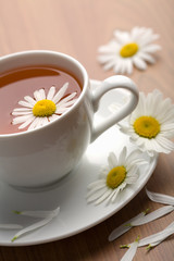Obraz na płótnie Canvas biała filiżanka herbaty ziołowe i kwiatów rumianku