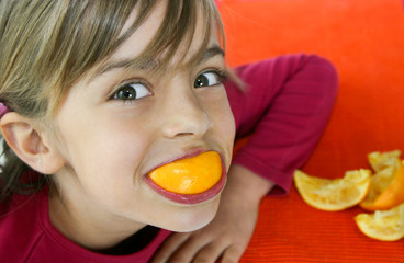 petite fille grimaçant avec son orange