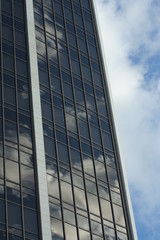 Fototapeta na wymiar grattacielo che riflette il cielo nuvoloso