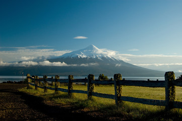 Snow peeked volcano from fenced field, Patagonia Chile