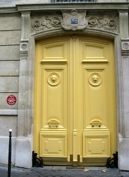 Porte coch&egrave;re jaune dans une rue de Paris.