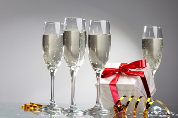 Glasses of champagne, gifts with red tapes and bows