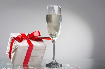 Glasses of champagne, gifts with red tapes and bows