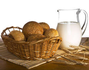 Jug with milk, bread and wheat