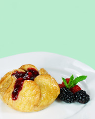 Fruit pastry with fresh berries on a green background