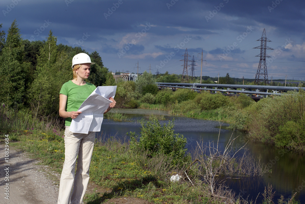 Wall mural woman engineer or architect with white safety hat, drawings and