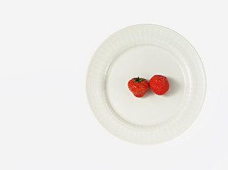two strawberries on white plate