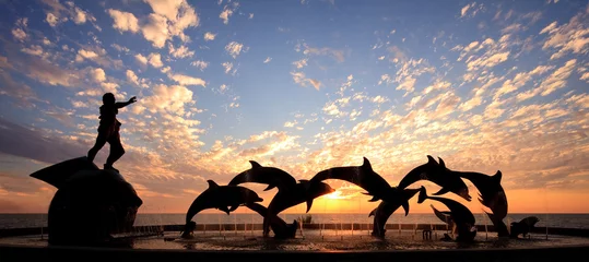 Foto auf Acrylglas Meer / Sonnenuntergang Delphinstatue vor Sonnenuntergang