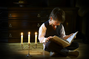 boy reads the fairytale in cadlelight - 10888497