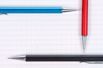 empty page of notebook and black, red, blue pencil
