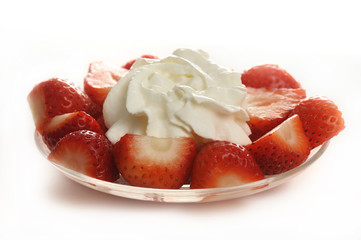 Cut strawberries with cream on the plate on a white background