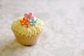 Cute cupcake with yellow frosting and gumpaste flowers