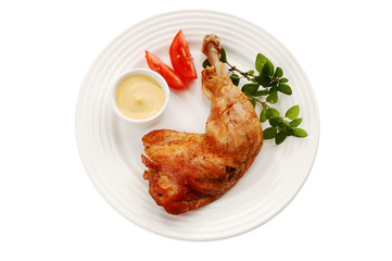 Roasted chicken leg with vegetables isolated on white