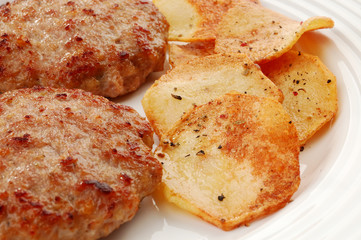 Fried steaks with chips and vegetable salad isolated on white