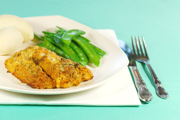 Fresh cod with snow peas and potatoes on a plate
