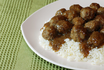 Meatballs and rice with gravy on a green tablecloth