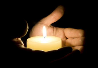 Human hands holding candle