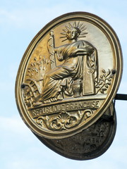 Plaque République Française dorée, ciel bleu.