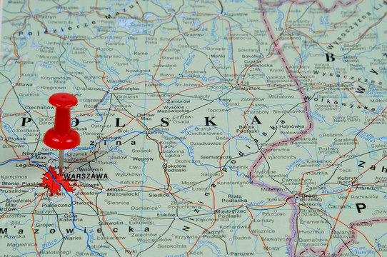 Fototapeta Pin pointing Warsaw on polish map in atlas