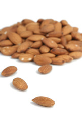 It is a lot of nuts of almonds on a white background