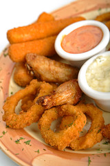 Rings of a squid, fish sticks, chicken hips with sauce.